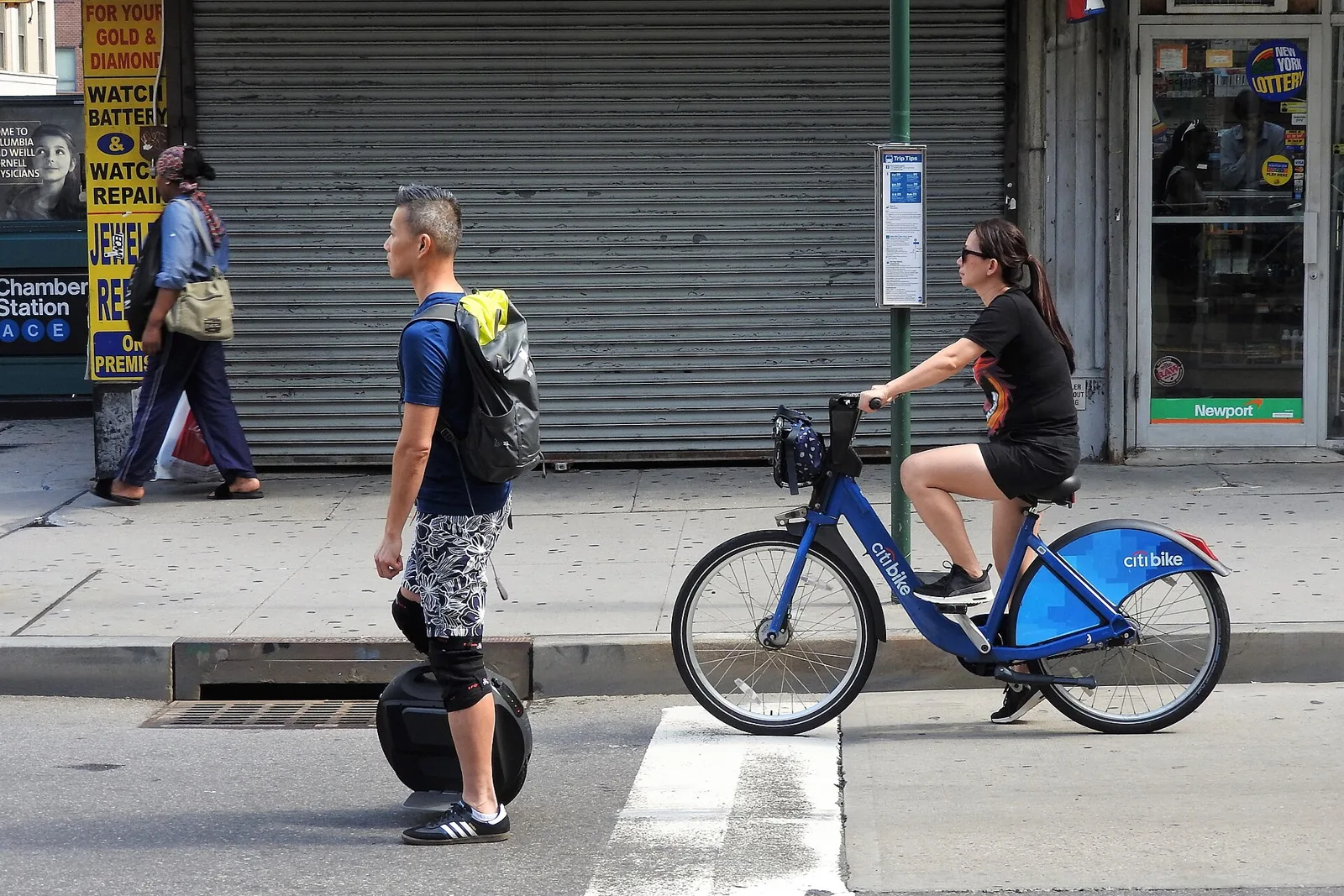 Rider en gyroroue attendant à un passage piéton en ville à côté d'une cycliste