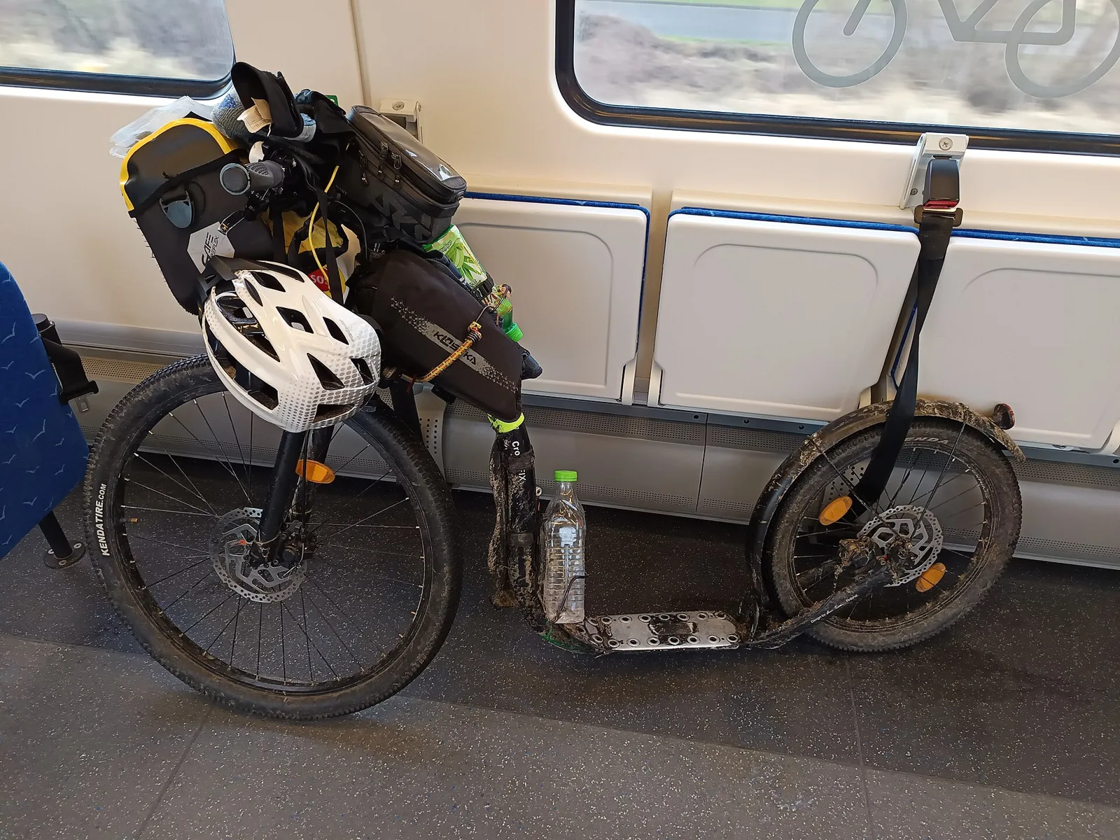Trottinette chargée de sacs et d'un casque rangée dans un wagon de train régional